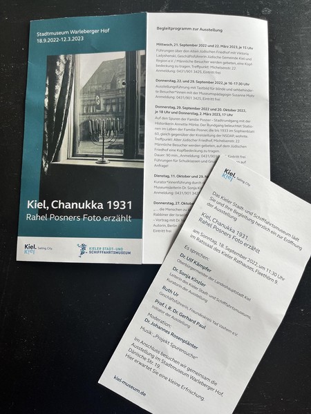 Das Bild zeigt eine Einladungskarte zu einer Ausstellung mit dem Titel: „Kiel, Chanukka 1931 – Rahel Posners Foto erzählt“