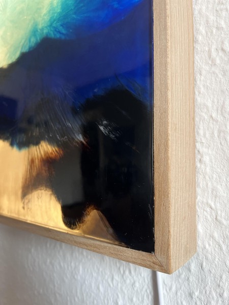 Das Bild zeigt einen der beiden Kästen im Anschnitt, sodass man das Material Holz und einen hinterleuchteten Ausschnitt der Meeresdarstellung erkennt.